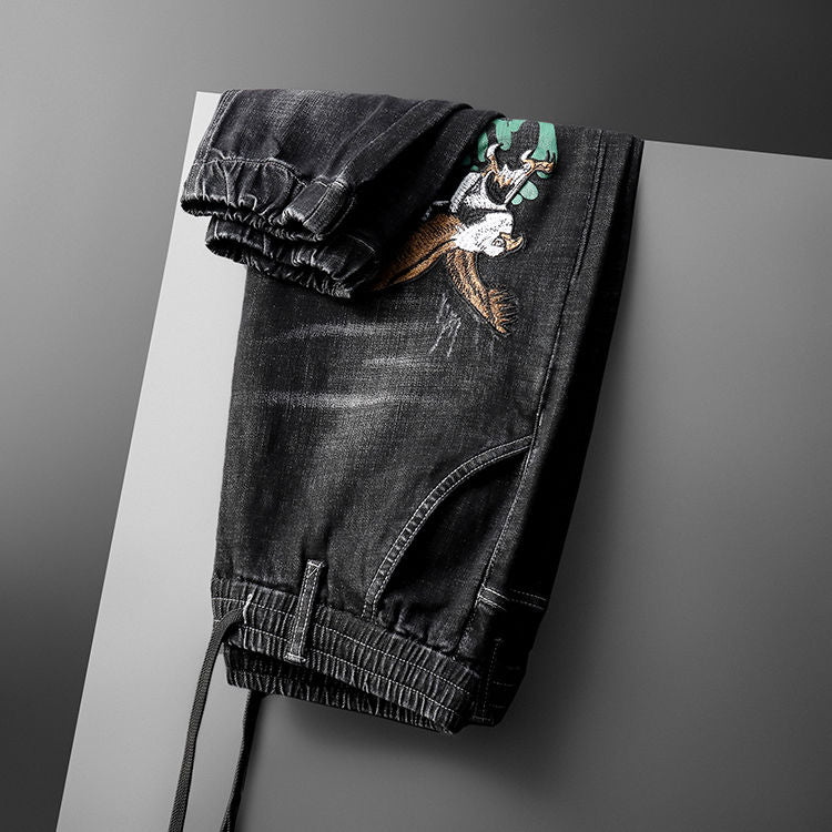 Vaqueros negros decorados con bordado de águila y palabras